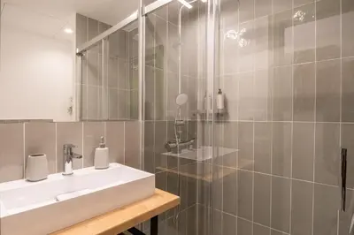 a kitchen with a white refrigerator and a sink at Charming renovated Apt minutes from the center in Barcelona