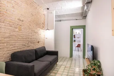 a living room with a table and a couch at Charming renovated Apt minutes from the center in Barcelona