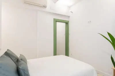 a bedroom with a white bed and a window at Charming renovated Apt minutes from the center in Barcelona