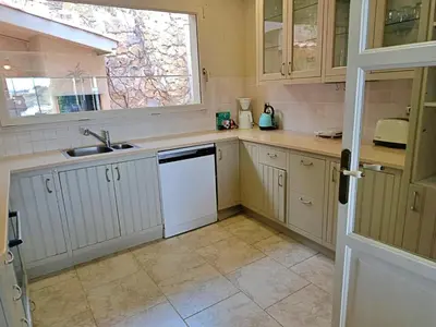 a kitchen with white cabinets and a sink and a window at Preciosa casa al borde de un acantilado in Arenys de Mar