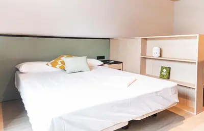 a bedroom with a large white bed and shelves at Atenea Living in Mataró