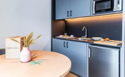 a small kitchen with a table and a sink at Atenea Living in Mataró