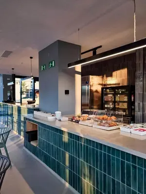 a restaurant with a counter with food on it at Atenea Living in Mataró