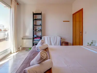 a bedroom with a bed with towels on it at Castell Apartment by Hello Homes Sitges in Sitges
