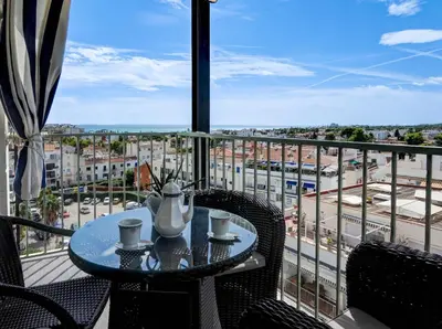 a table on a balcony with a view of a city at Atalaya Apartment by Hello Homes Sitges in Sitges