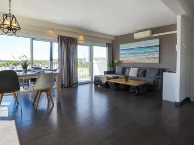 a living room with a couch and a table at Atalaya Apartment by Hello Homes Sitges in Sitges