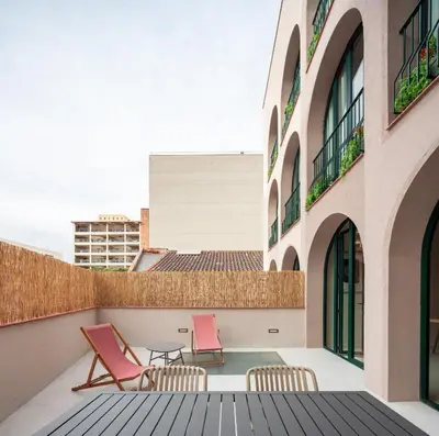 a living room with a couch and a kitchen at Casa Badajoz in Barcelona