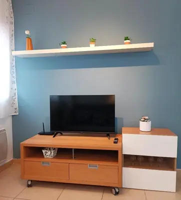 a television on a wooden entertainment center with a shelf at Apartamento Gerimar - Gelida/Bcn in Gélida