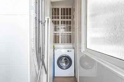 a washer and dryer in a bathroom with a window at 3 Bdr Apt In Cornella 5 Mins Form The Metro in Cornellà de Llobregat