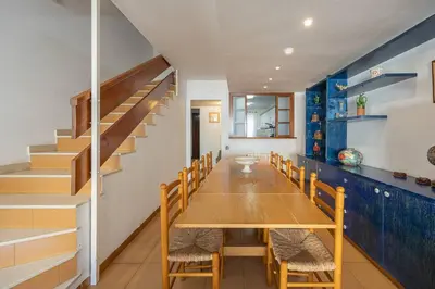 a dining room with a table and chairs and stairs at House 5 Mins From Montgat Beach in Montgat