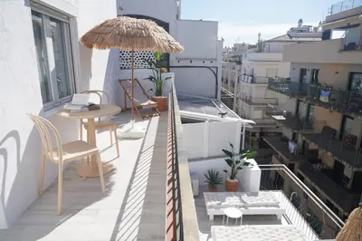 a balcony with a table and chairs and an umbrella at Aldara Sitges in Sitges