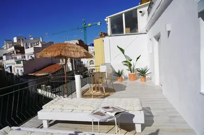 a balcony with chairs and an umbrella on a building at Aldara Sitges in Sitges