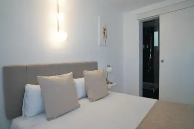 a bedroom with a bed with white sheets and pillows at Aldara Sitges in Sitges