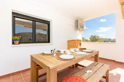 a wooden pergola with a table and chairs on a patio at Villa Serranita - Stylish Holiday Home with Views and Air Conditioning 15 mins to Sitges in Olivella