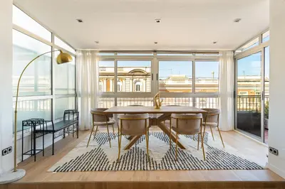 a dining room with a table and chairs and a large window at Sunny 3BR2BA w Private Terrace AC in Barcelona