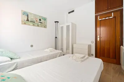 a room with two beds and a wooden door at Sunny 3BR2BA w Private Terrace AC in Barcelona