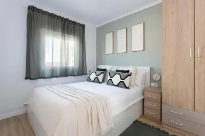 a bedroom with a white bed with pillows and a window at Lovely Attic With Terrace in Hospitalet de Llobregat
