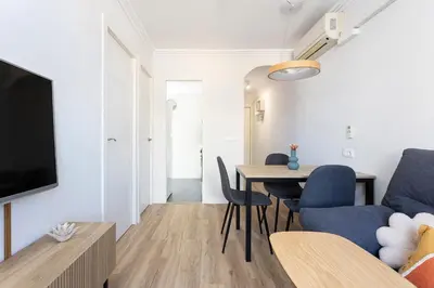 a living room with a table and a blue couch at Lovely Attic With Terrace in Hospitalet de Llobregat