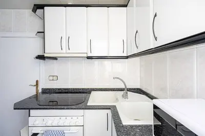 a white kitchen with white cabinets and a sink at 2 Bdr Apt In Cornella 5 Mins Form The Metro in Cornellà de Llobregat