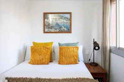 a bedroom with a white bed with yellow pillows at 2 Bdr Apt In Cornella 5 Mins Form The Metro in Cornellà de Llobregat