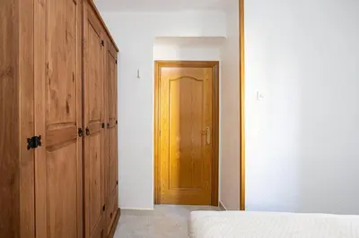 a bedroom with a wooden closet and a door at Cozy Apt In Cornella 2 Mins From The Metro in La Gabarra