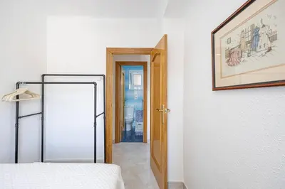 a bedroom with a bed and a door to a hallway at Cozy Apt In Cornella 2 Mins From The Metro in La Gabarra
