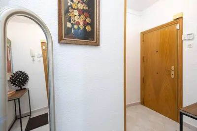 a mirror in a room with a painting on the wall at Cozy Apt In Cornella 2 Mins From The Metro in La Gabarra