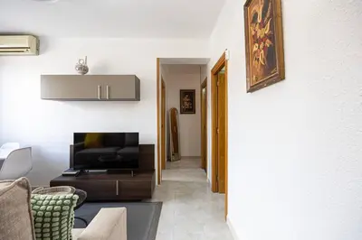 a living room with a couch and a television at Cozy Apt In Cornella 2 Mins From The Metro in La Gabarra