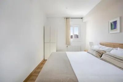 a white bedroom with a large bed and a window at Amazing 3bdr Apt In Cornella 1 Mins From Metro in Cornellà de Llobregat
