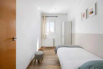 a white bedroom with a bed and a window at Amazing 3bdr Apt In Cornella 1 Mins From Metro in Cornellà de Llobregat