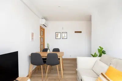 a living room with a table and chairs and a couch at Amazing 3bdr Apt In Cornella 1 Mins From Metro in Cornellà de Llobregat