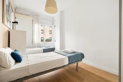 a bedroom with two beds and a window at Big Central Barcelona Flat - 4BR for 7 in Barcelona