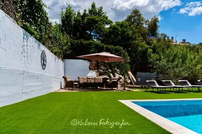 a patio with an umbrella and a swimming pool at Ca L’Oscana in Bigues i Riells