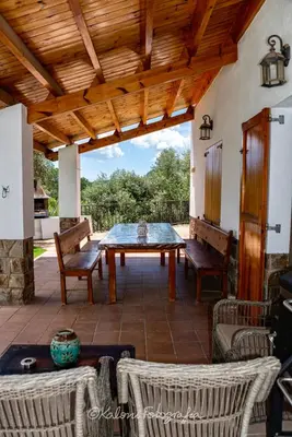 a patio with a table and chairs and a wooden ceiling at Ca L’Oscana in Bigues i Riells