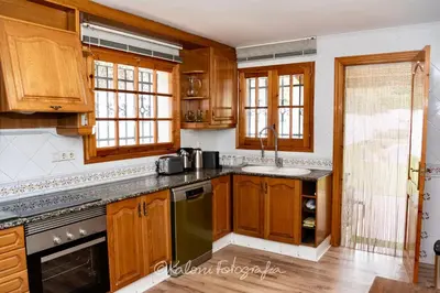 a kitchen with wooden cabinets and a sink at Ca L’Oscana in Bigues i Riells