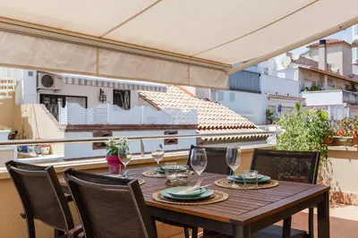 a wooden table with wine glasses on a balcony at SOUL by Hello Homes Sitges in Sitges