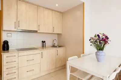a kitchen with a table and a vase of flowers at SOUL by Hello Homes Sitges in Sitges