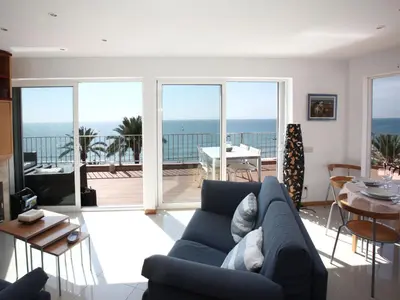 a living room with a couch and a view of the ocean at Sitges Views in Sitges