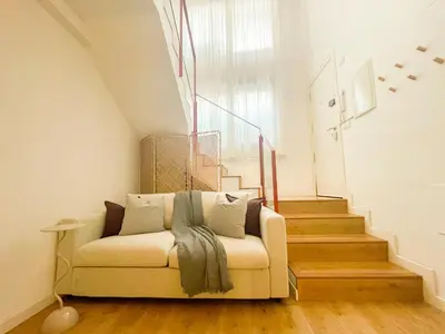 a white couch in a room with a staircase at Boutique Llobregat in Hospitalet de Llobregat
