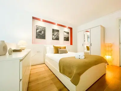 a white bedroom with a bed and a desk at Boutique Llobregat in Hospitalet de Llobregat