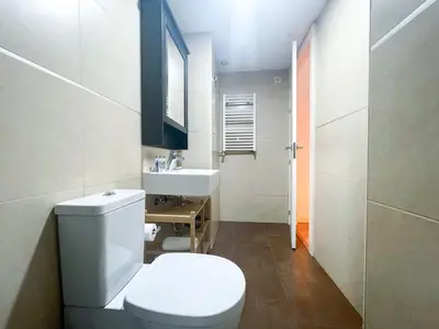 a bathroom with a white toilet and a sink at Boutique Llobregat in Hospitalet de Llobregat
