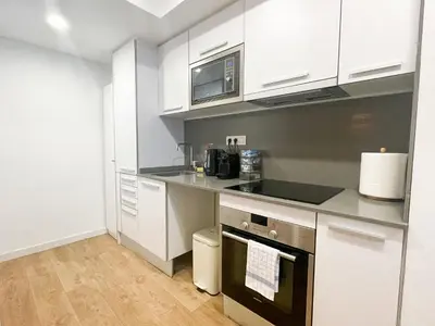 a kitchen with white cabinets and a stove top oven at Boutique Llobregat in Hospitalet de Llobregat