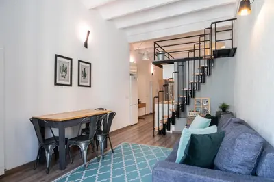 a living room with a blue couch and a table at Beautiful renovated Loft minutes from the beach in Barcelona
