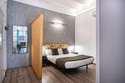 a bedroom with a bed and a mirror at Beautiful renovated Loft minutes from the beach in Barcelona