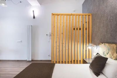 a bedroom with a bed with a wooden headboard at Beautiful renovated Loft minutes from the beach in Barcelona