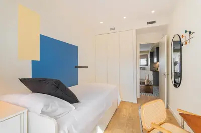 a bedroom with a white bed and a blue wall at Sagrada Familia Apartment by Olala Homes in Barcelona
