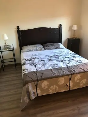a bedroom with a bed with a floral bedspread at Ca la Trini - turisme rural in Torrellas de Foix