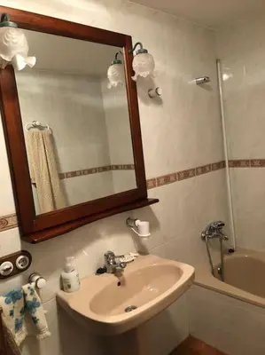 a bathroom with a sink and a mirror and a tub at Ca la Trini - turisme rural in Torrellas de Foix