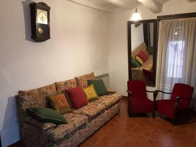 a living room with a couch and a mirror at Ca la Trini - turisme rural in Torrellas de Foix
