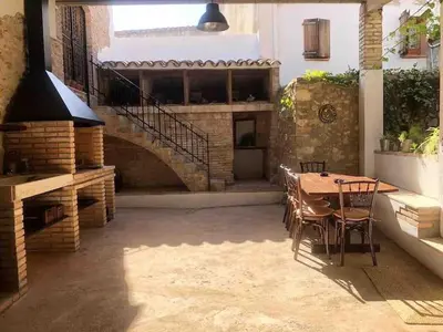 a patio with a table and chairs and a staircase at Ca la Trini - turisme rural in Torrellas de Foix